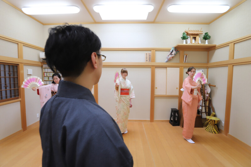 日本舞踊教室で先生の指導のもと生徒が扇を使った稽古を行っている様子