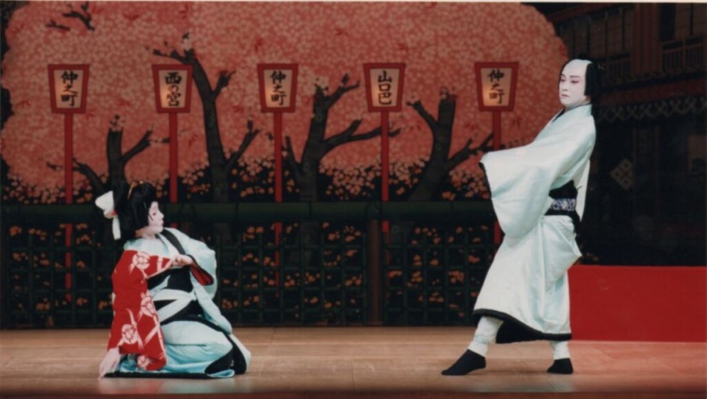 桜を背景に舞台で踊る男女の踊り手